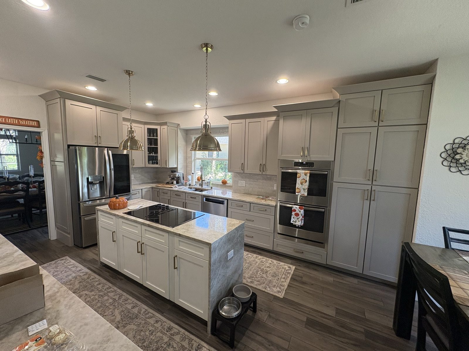 After: refaced Perfect Greige cabinets around the wall ovens and refrigerator