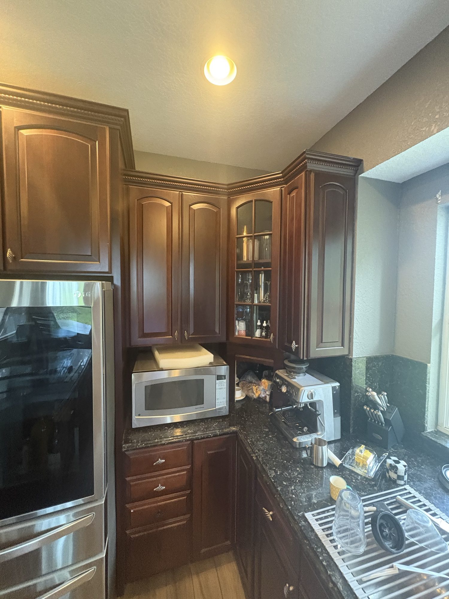 Before: dark cherry cabinets along the sink wall